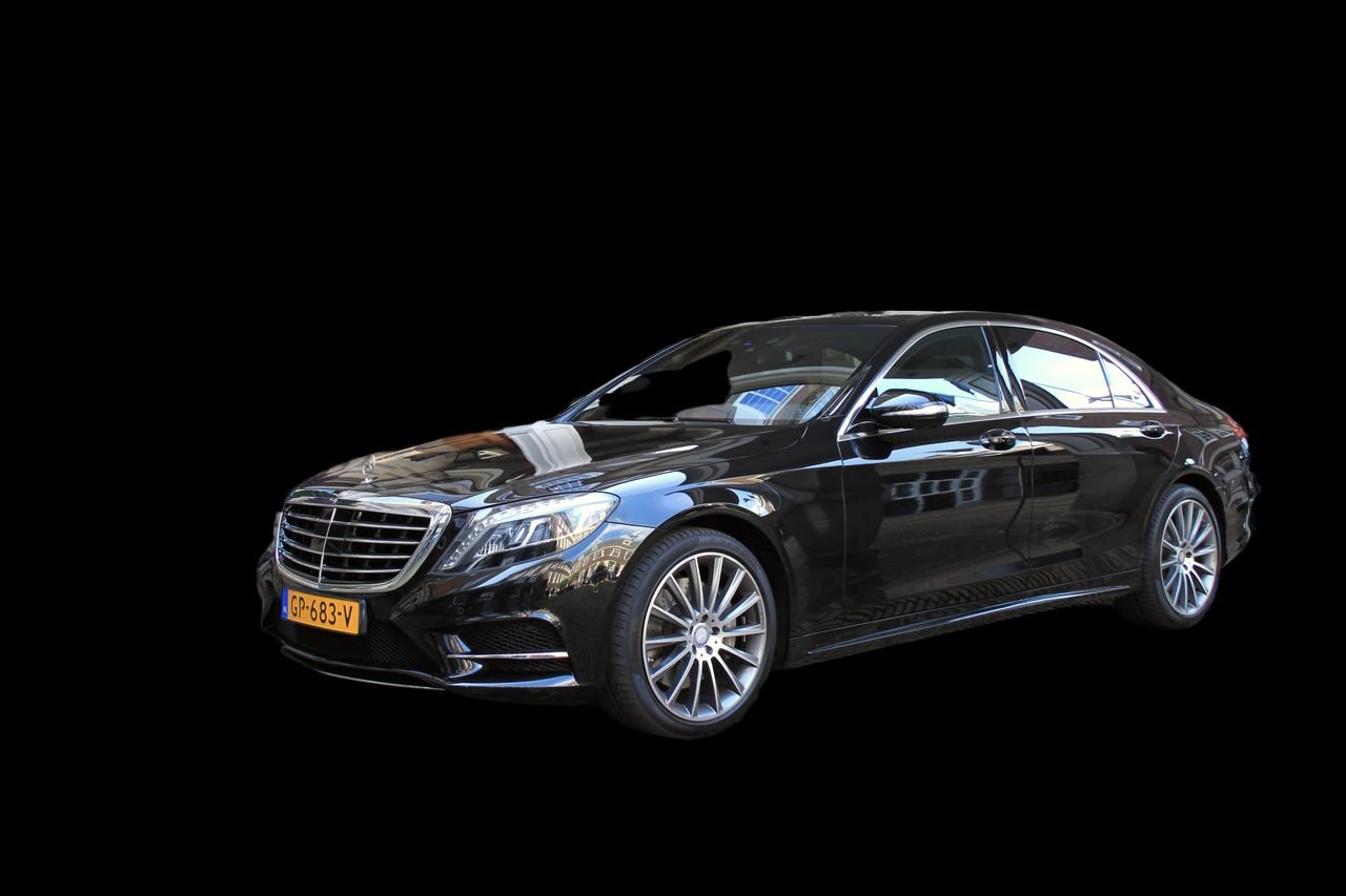 Black saloon car photographed against a black background